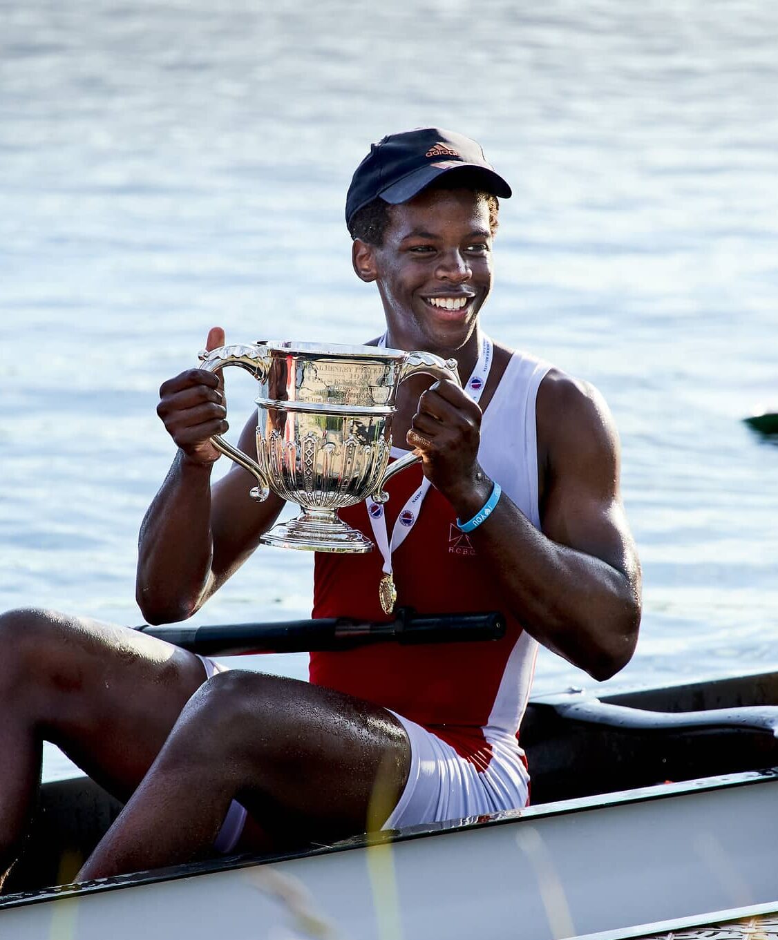 Male rower holding a trophy competing for Radley College