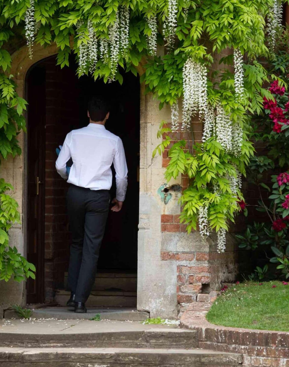 Boy walking through flowered doorway at Radley College
