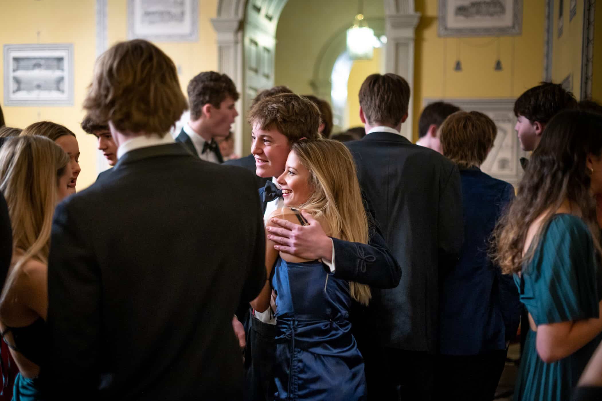 Boy in suit and girl in dress at a social event.