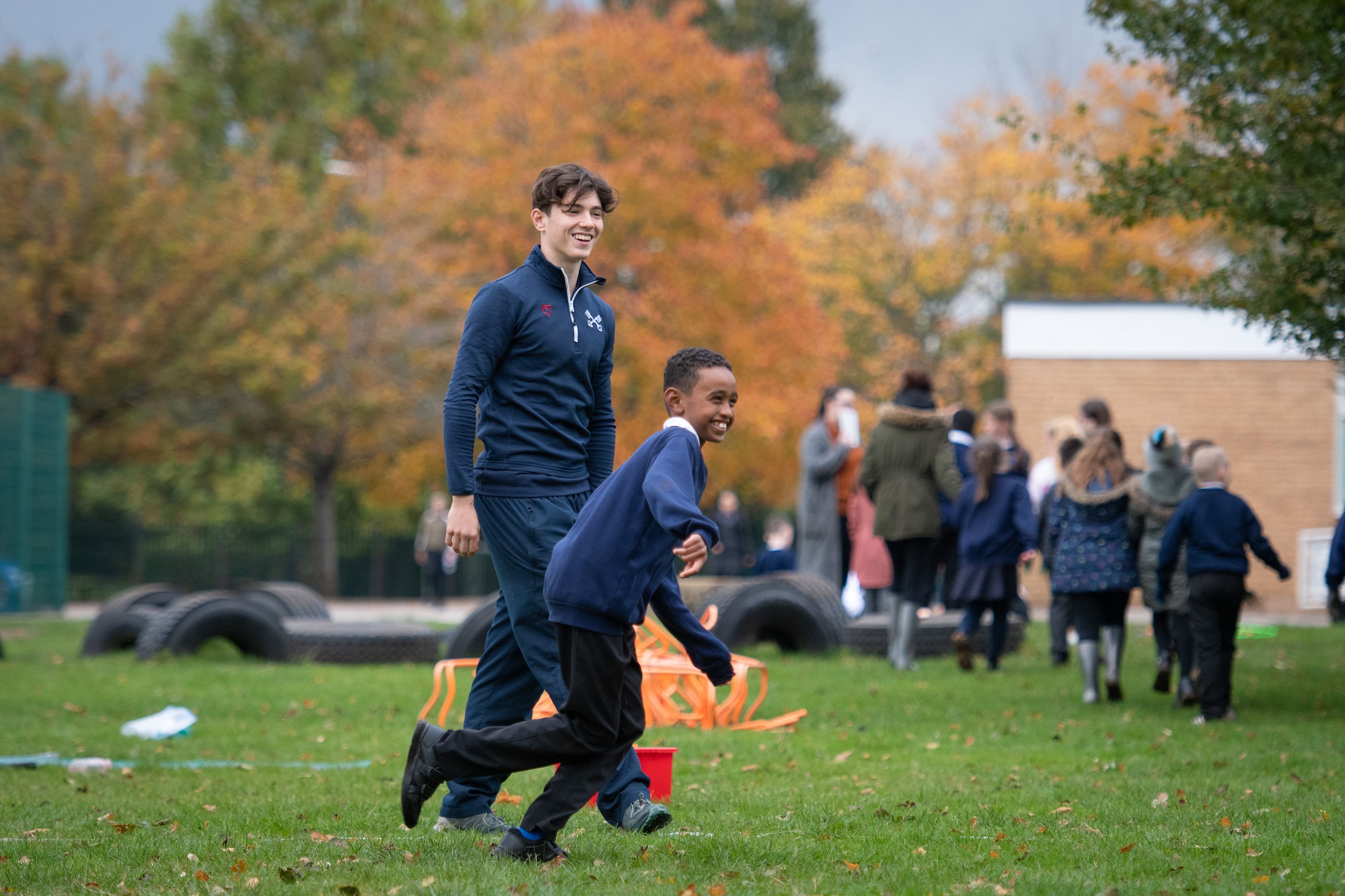 Partnerships at Radley College. Boy with primary school child outside.