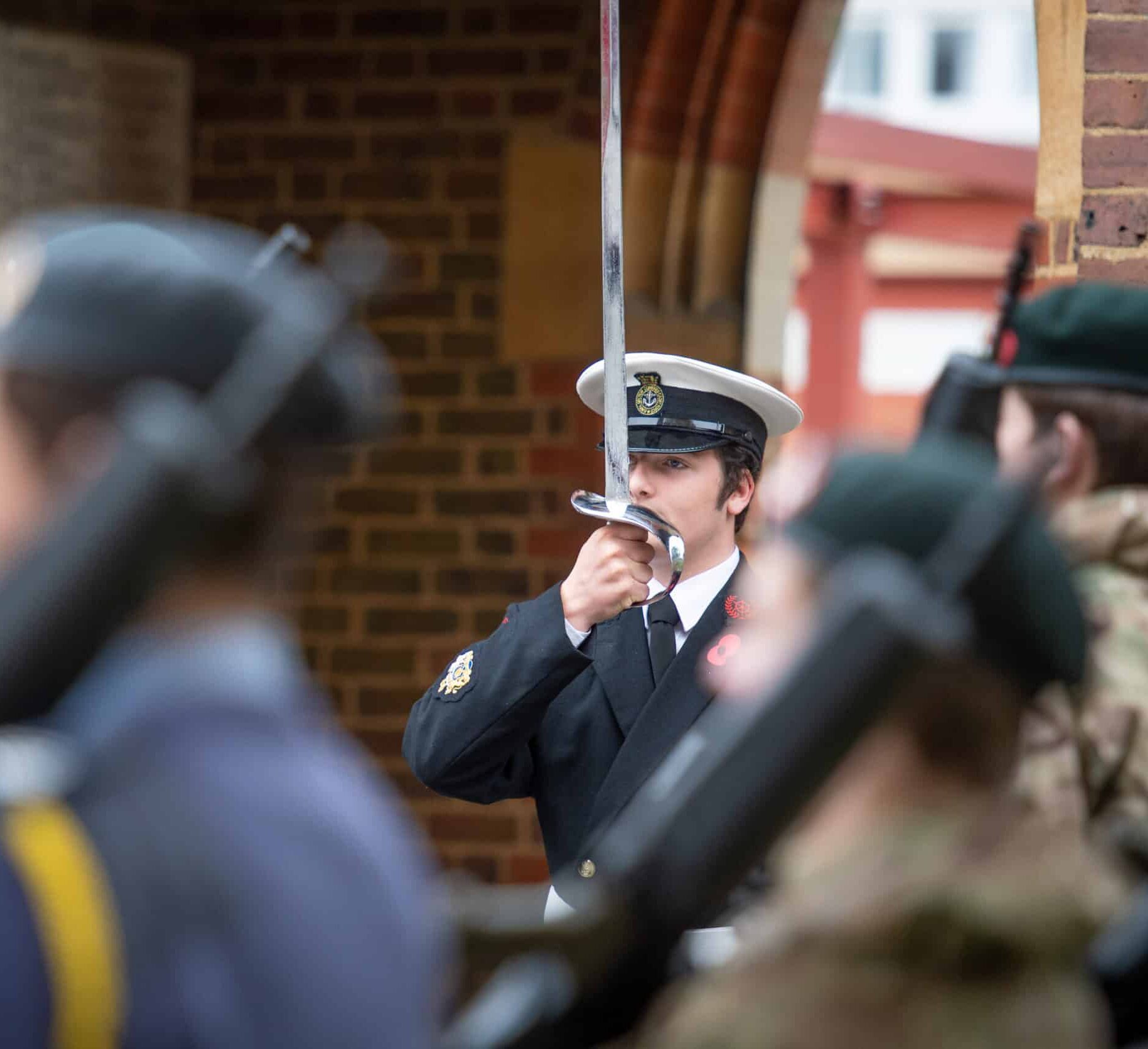 Boy in ceremonial Royal Navy cadet dress with sword