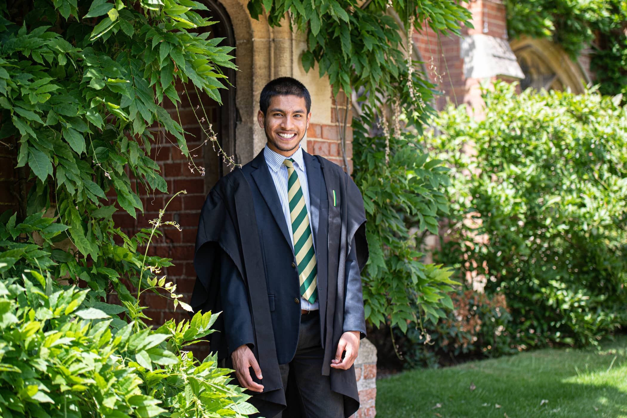 Boy stood in doorway with beautiful green plants surrounding him