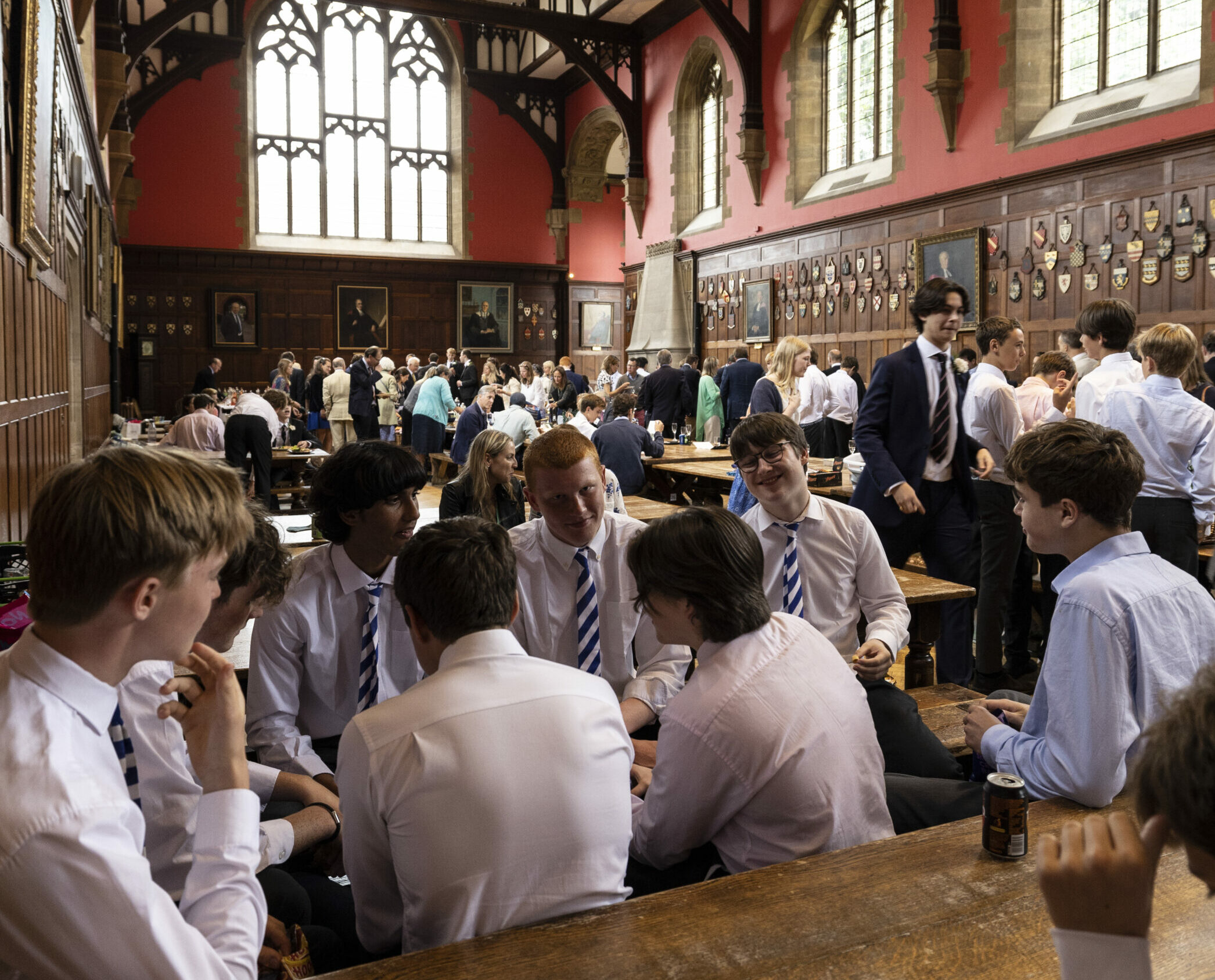 Boys sat in a large, grand dining hall eating and talking