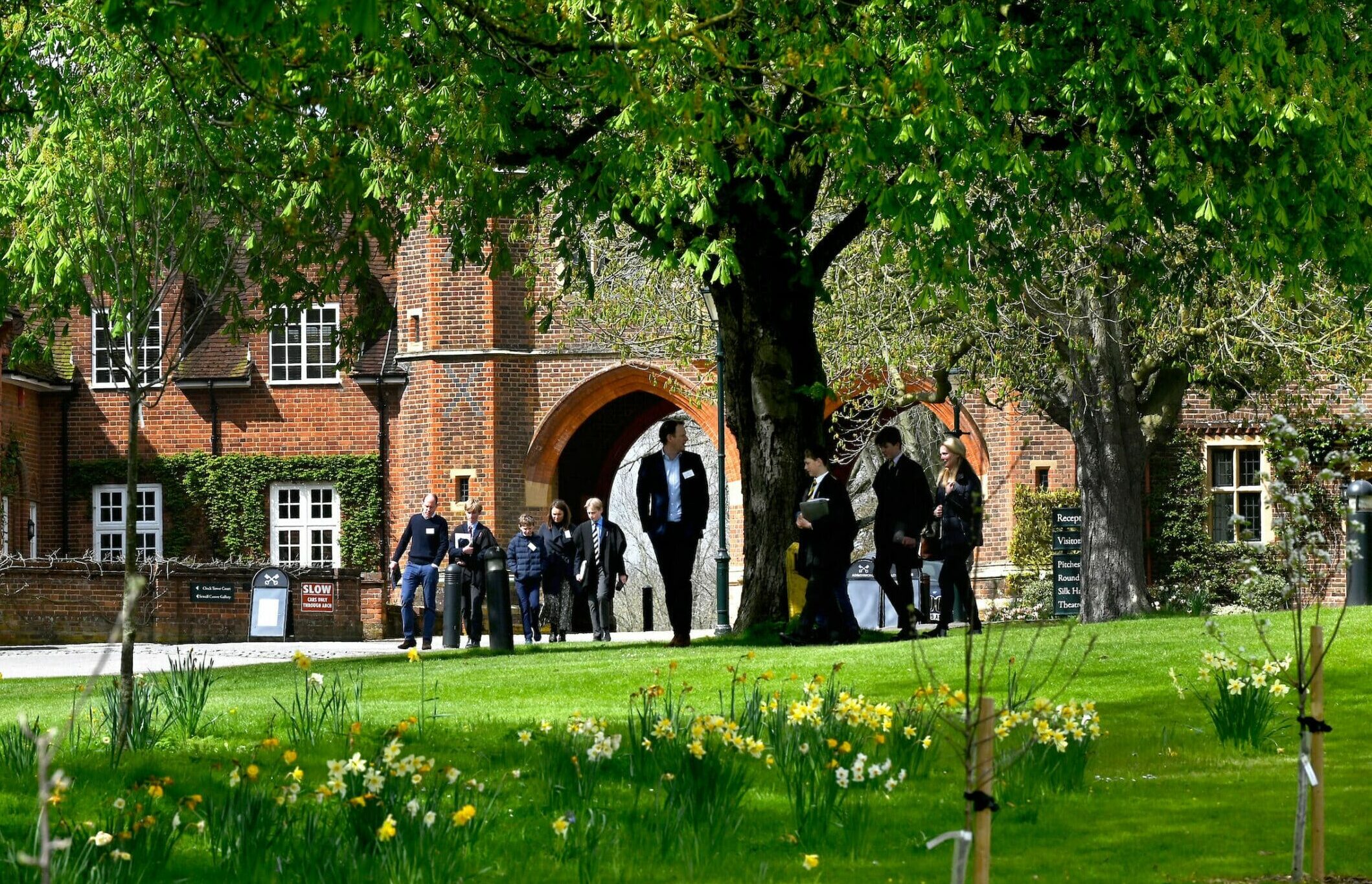 Families walk through the grounds of Radley College whilst visiting an open day