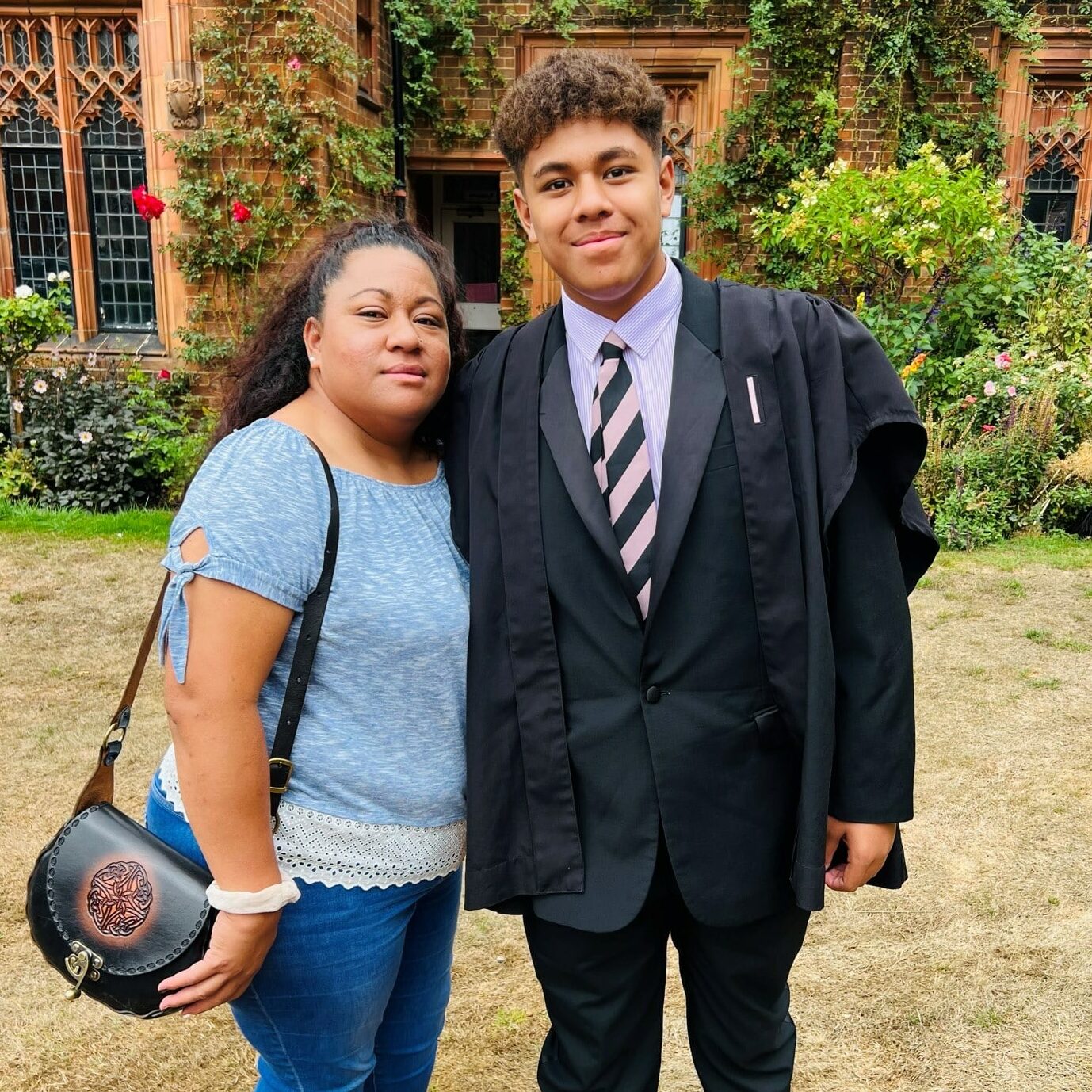 Moses and his mother Telisia standing together outside of Radley College building with roses in the background